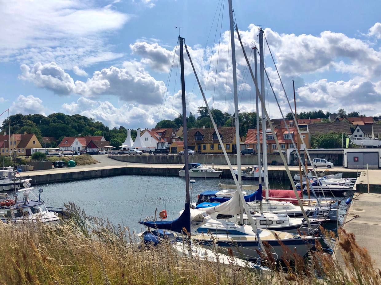 Hafenbecken mit einigen Segelbooten, im Hintergrund Fischerhäuser