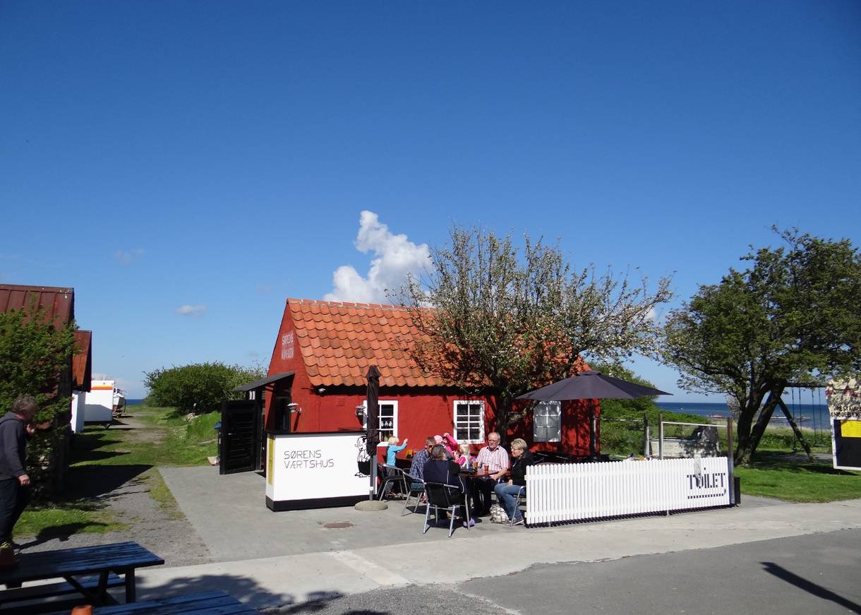Kleines, rotes Haus mit einer Gastterrasse