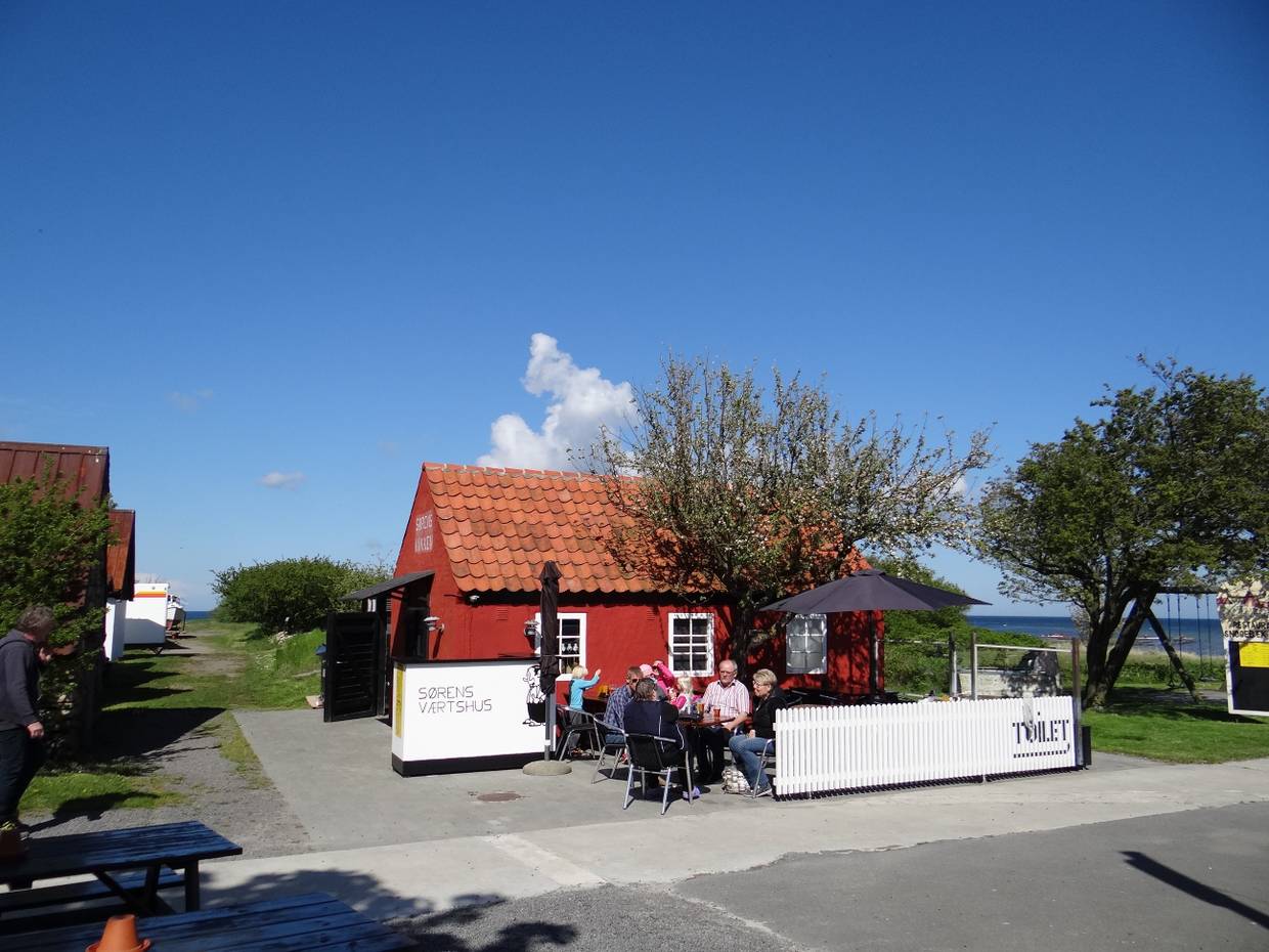 Kleines, rotes Haus mit einer Gastterrasse