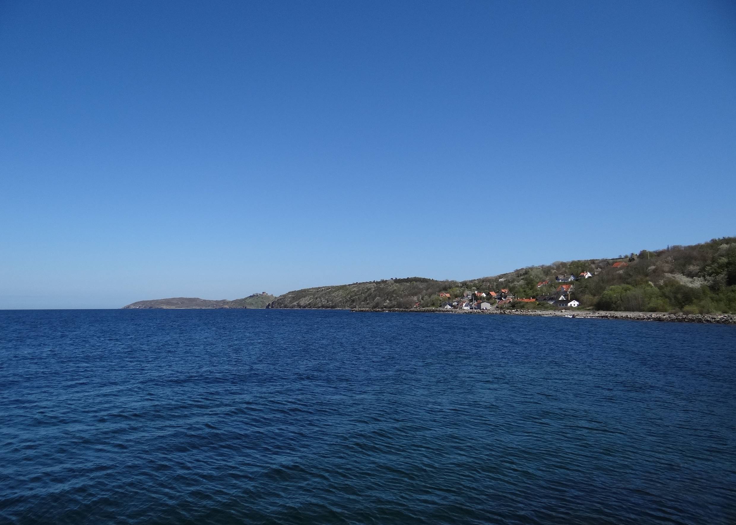 Aussicht auf ein Dorf und Felsen am blauen Meer