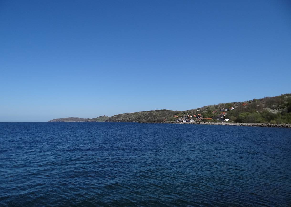 Aussicht auf ein Dorf und Felsen am blauen Meer