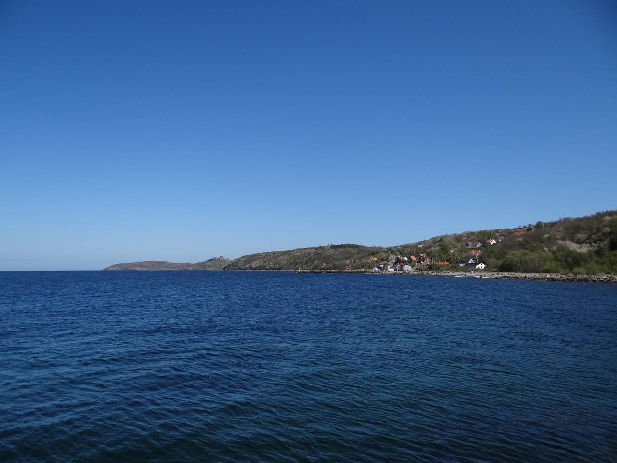 Aussicht auf ein Dorf und Felsen am blauen Meer