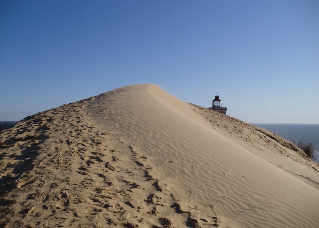 Verlassener Leuchtturm, der von hohen Sanddünen umgeben 