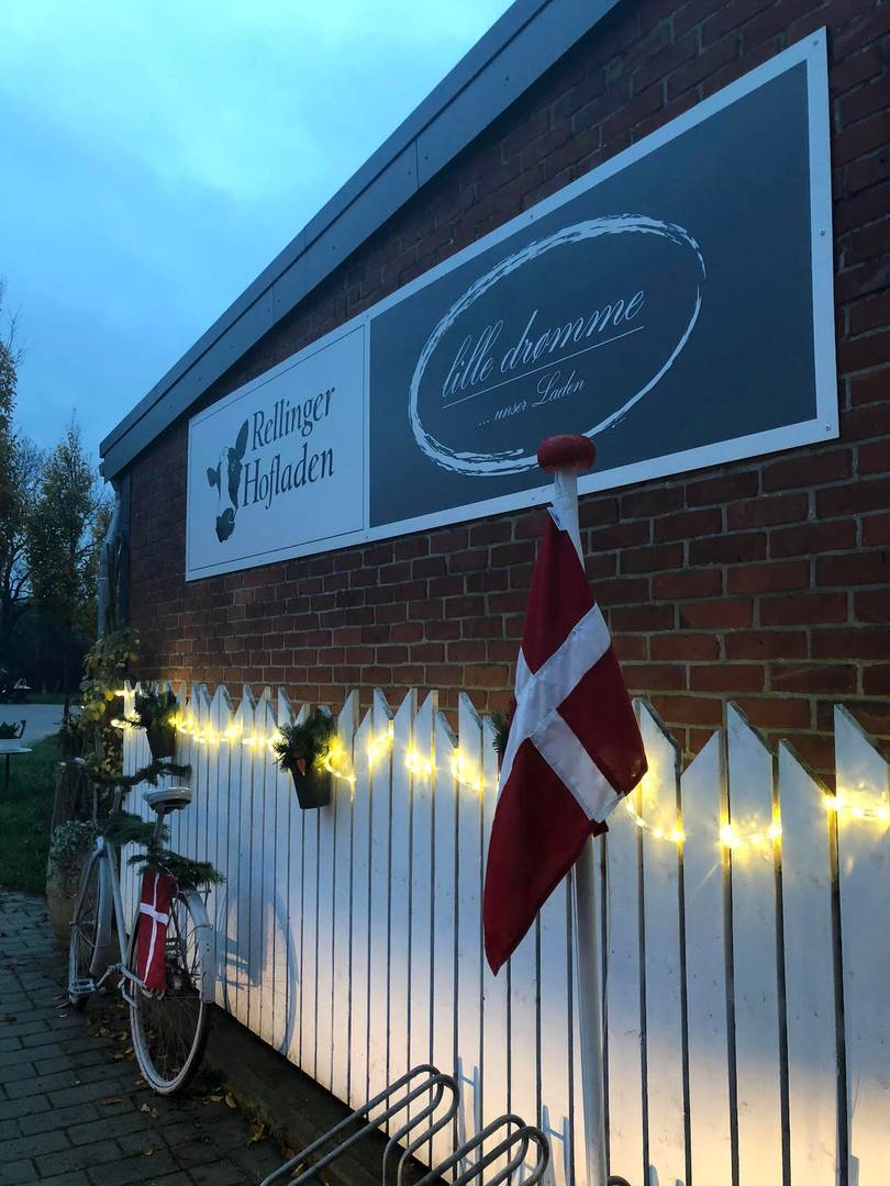 Ladenschild an einer Hauswand, darunter ein altes Fahrrad