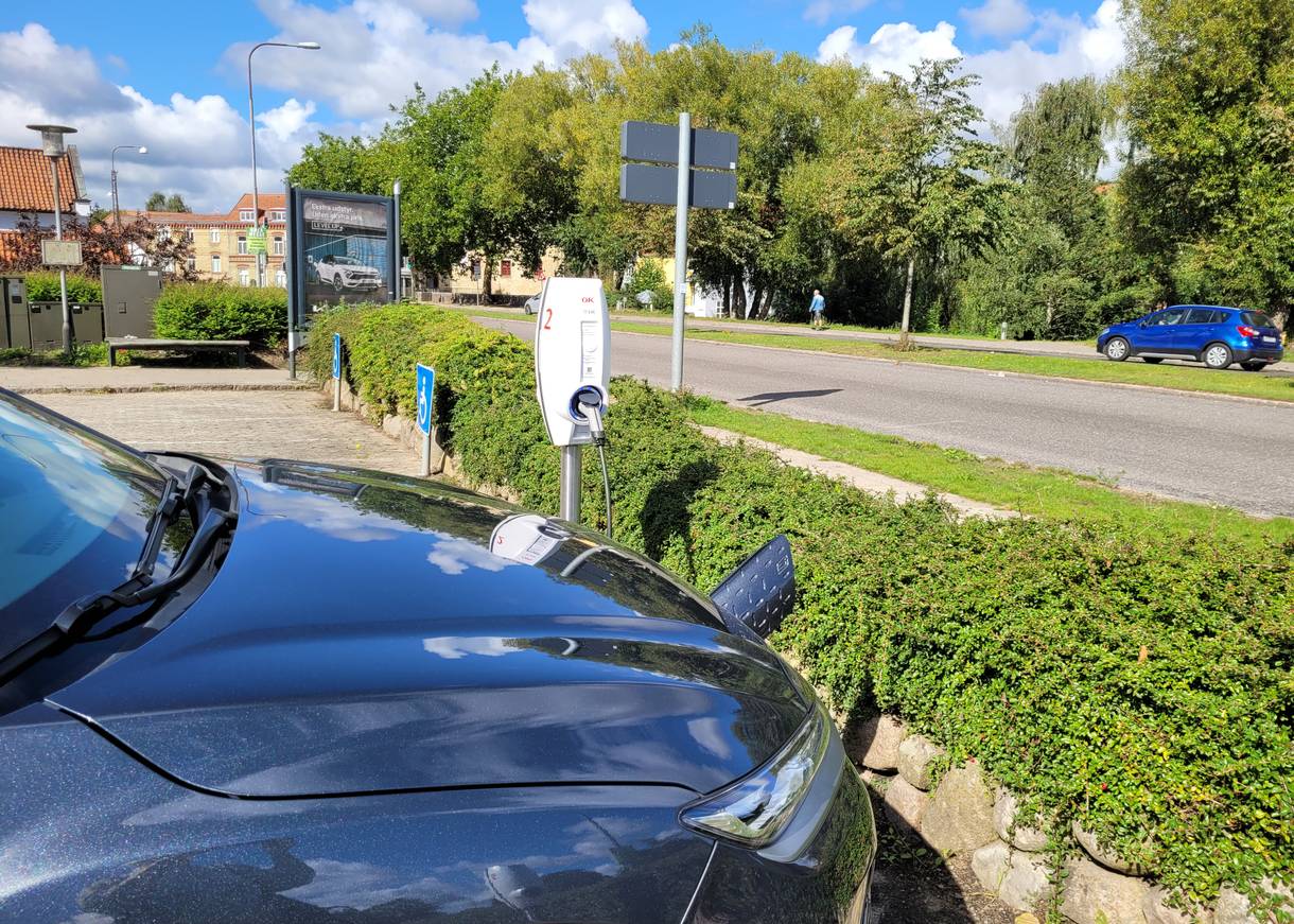 Ladesäule mit einem angeschlossenen Auto auf einem Parkplatz