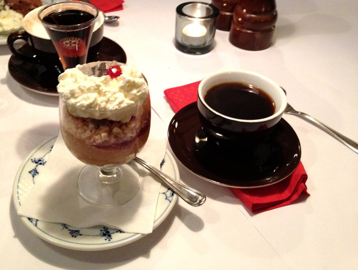Kaffegedeck mit Apfelkuchen im Glas und einem Schnaps