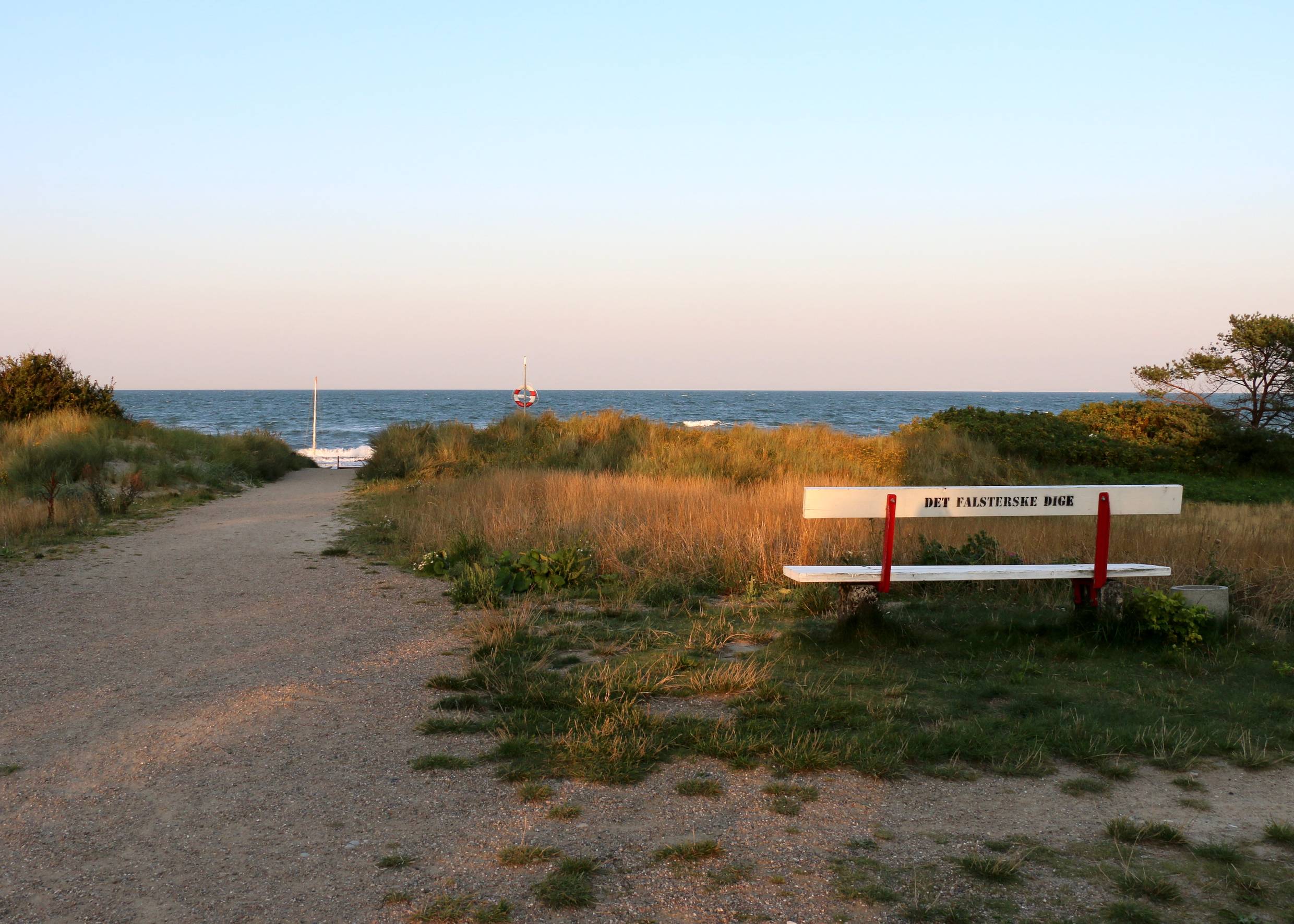 Abendsonne über einer Bank am Meer
