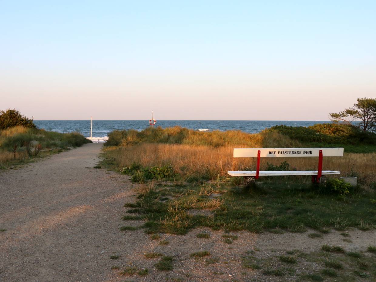 Abendsonne über einer Bank am Meer