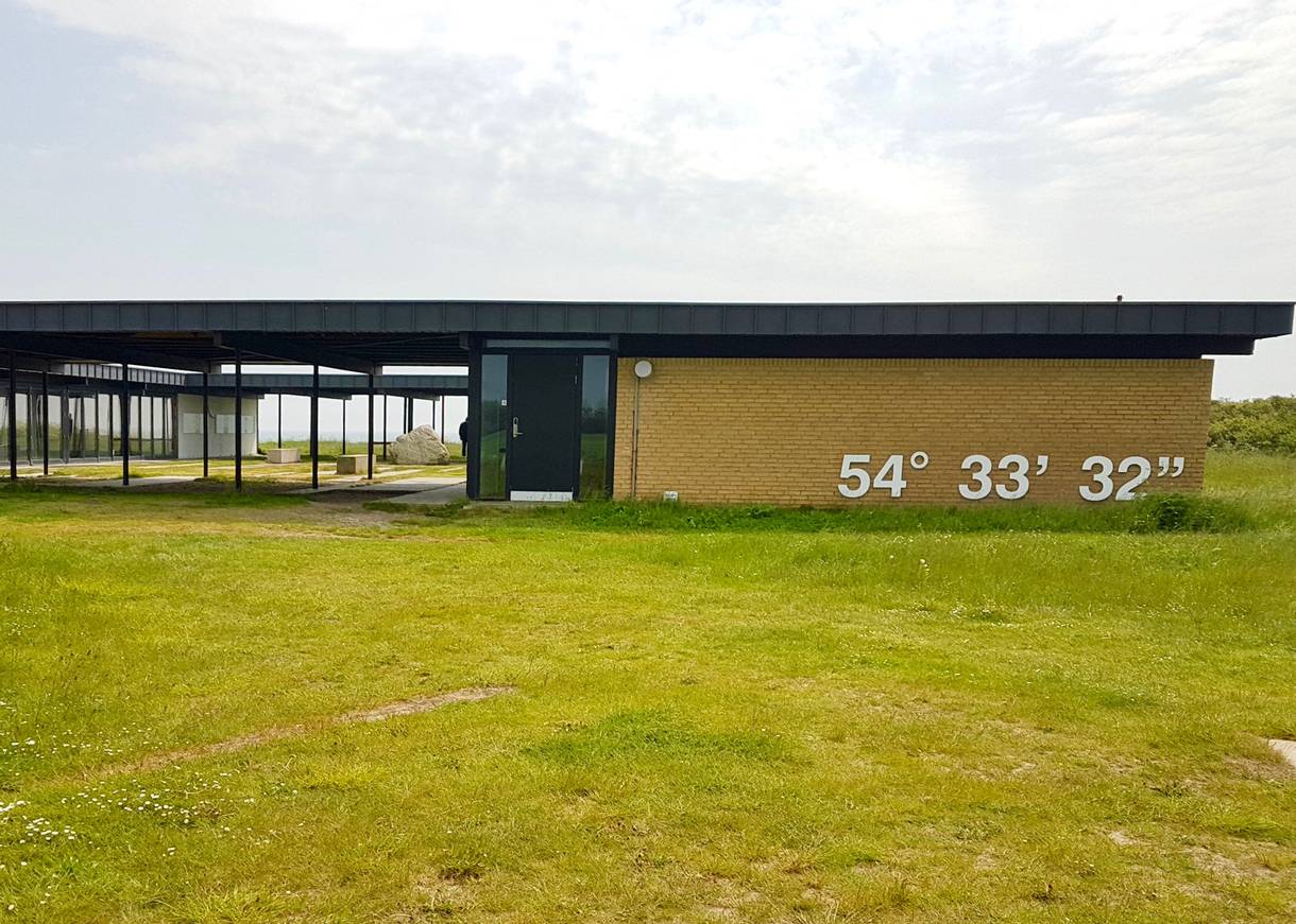 Gelbes, flaches Gebäude auf einer Wiese