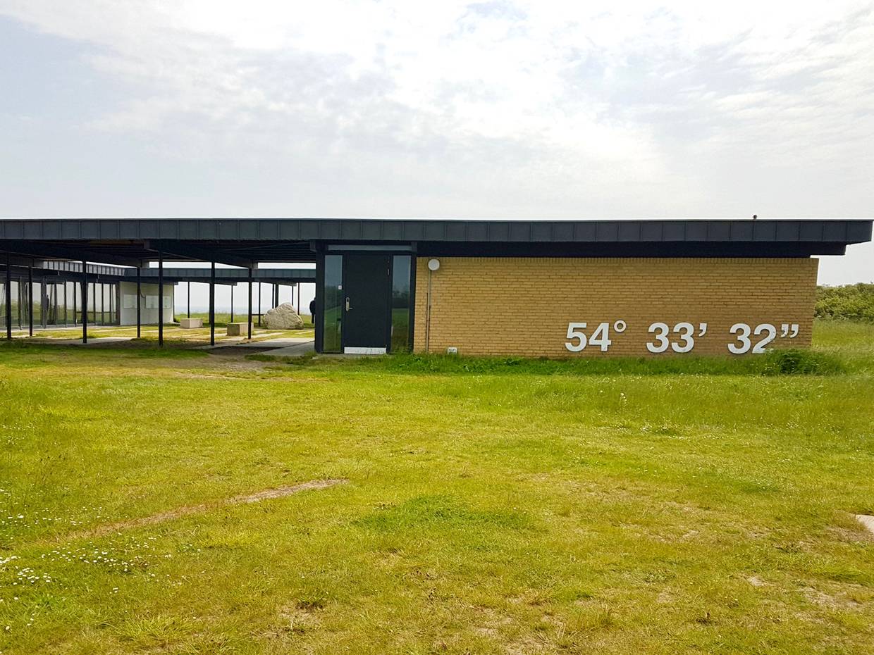 Gelbes, flaches Gebäude auf einer Wiese