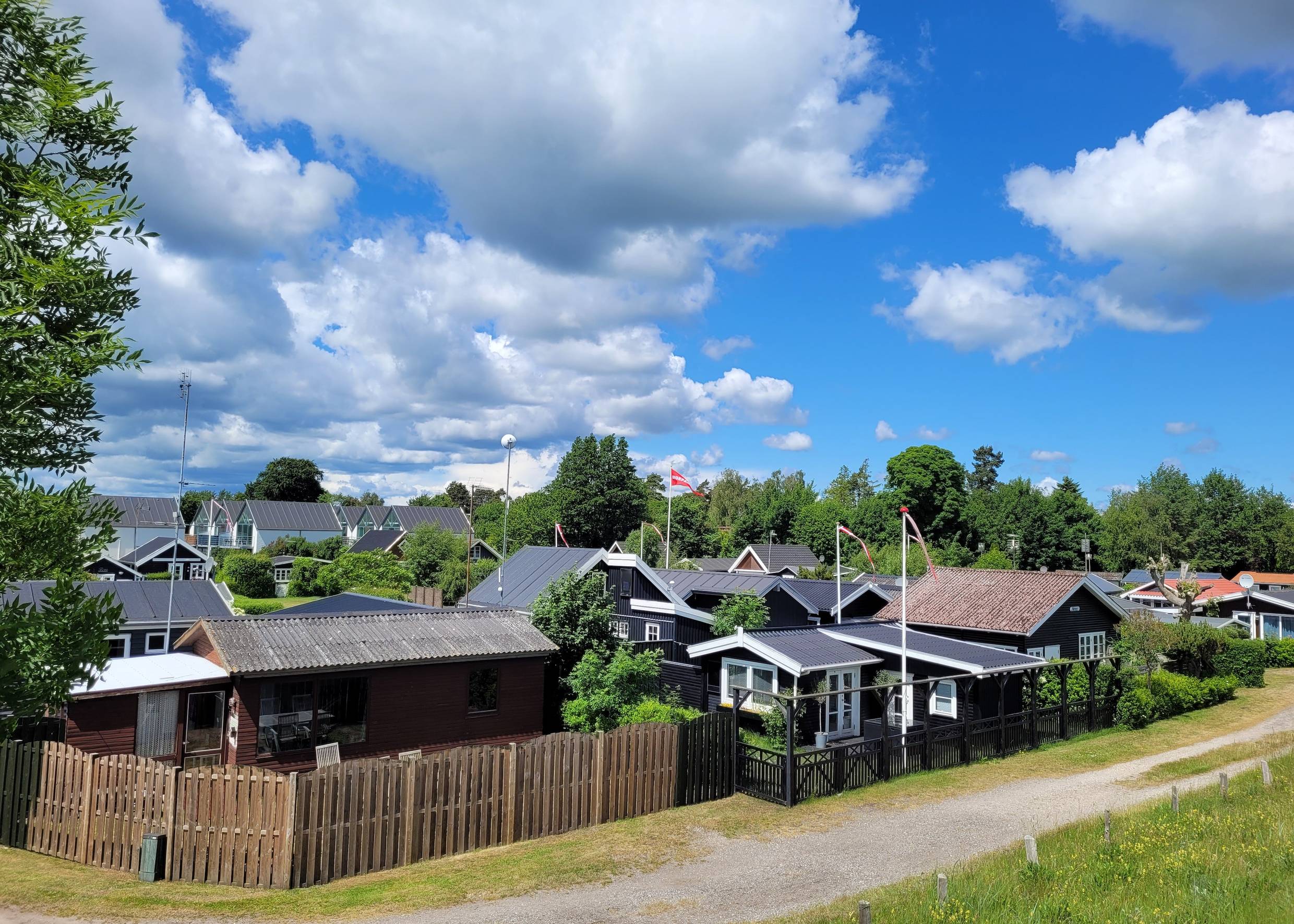 Blick auf eine Siedlung mit kleinen Ferienhäusern vor einem Waldstück