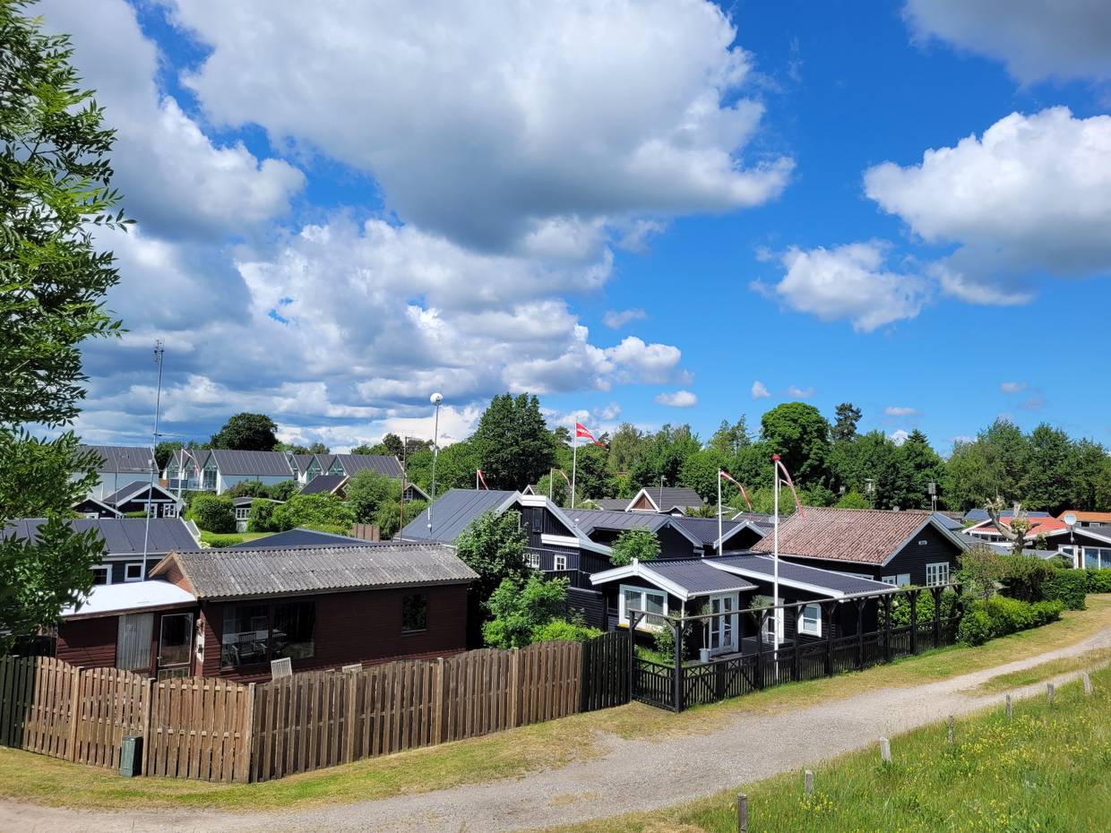 Blick auf eine Siedlung mit kleinen Ferienhäusern vor einem Waldstück