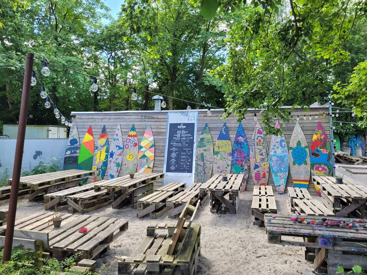 Strandbar mit Palettenmöbeln und bunten Surfboards als Deko