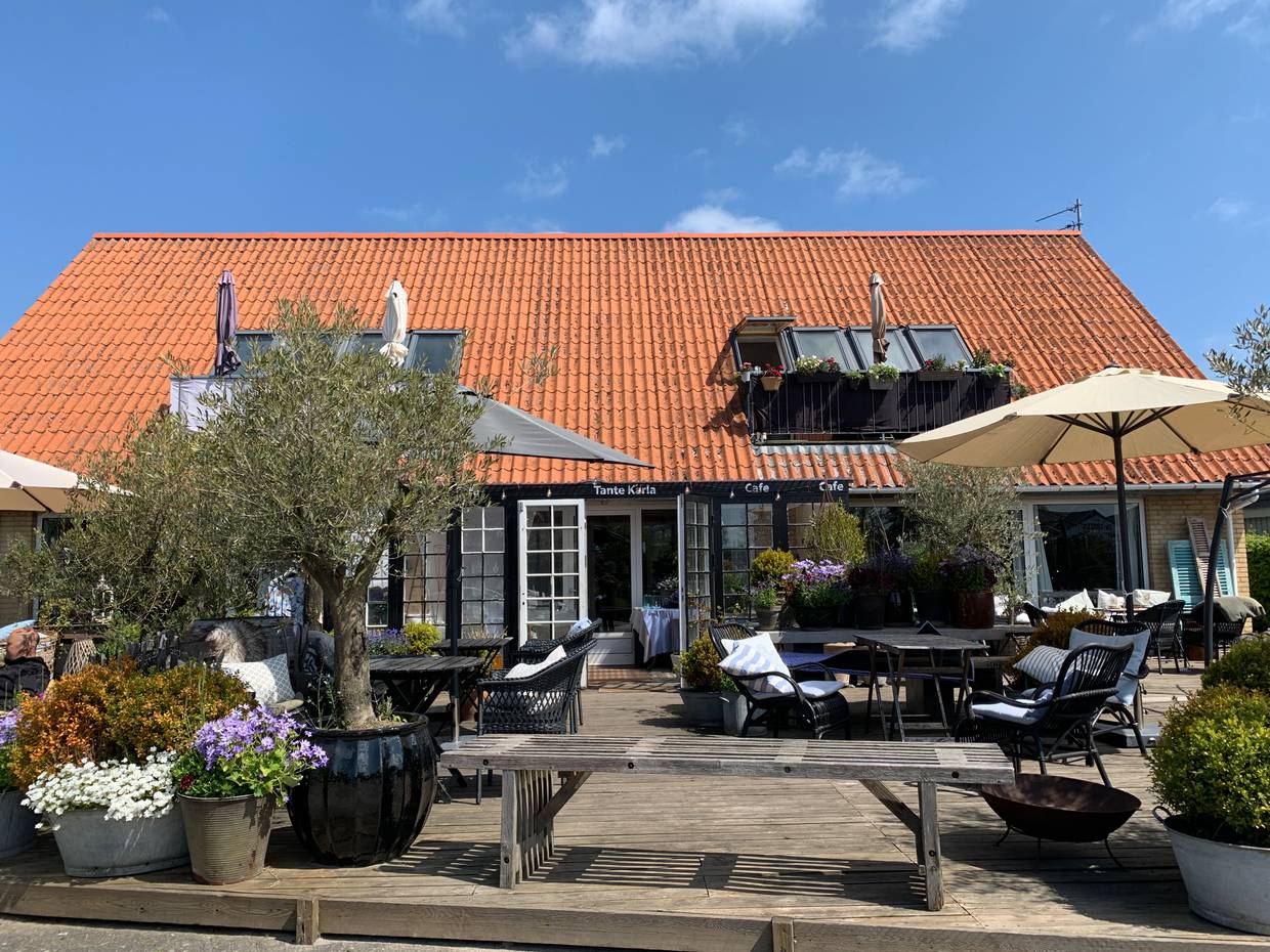Café-Terrasse mit vielen Blumen und Gartenmöbeln