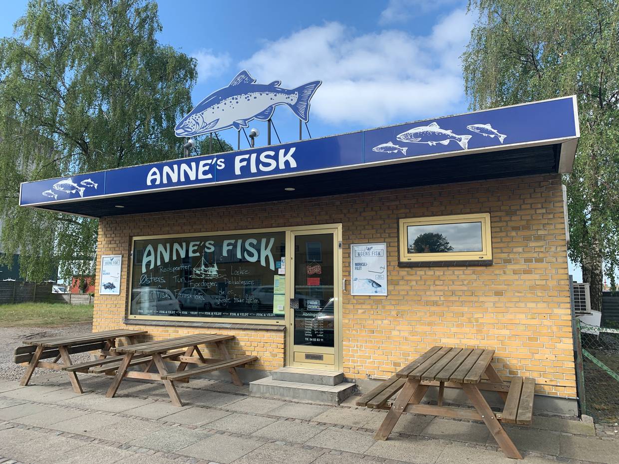Kleines Ladengeschäft mit Fischimbiss, davor Picknickbänke 