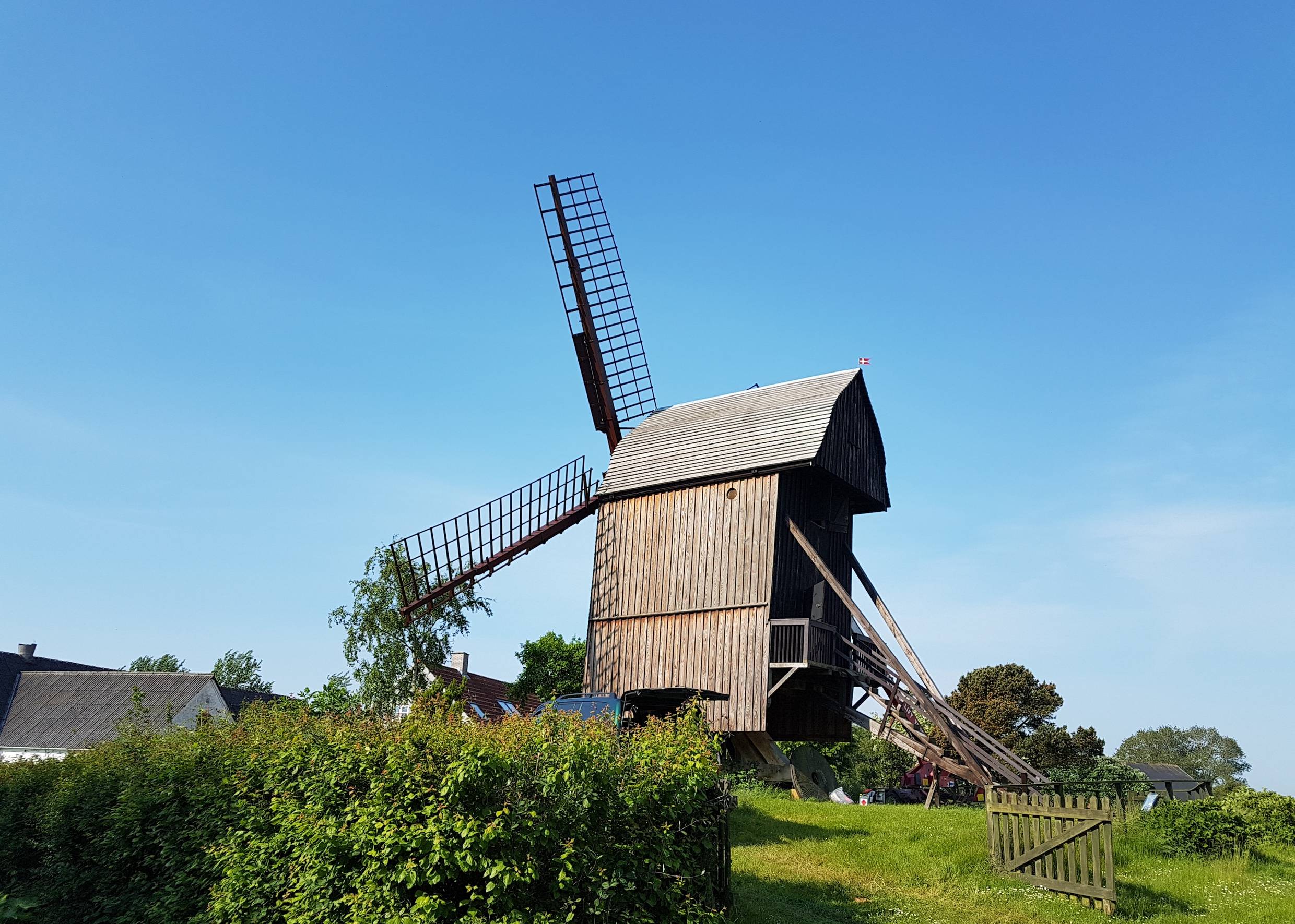 Alte Mühle aus Holz auf einer grünen Wiese