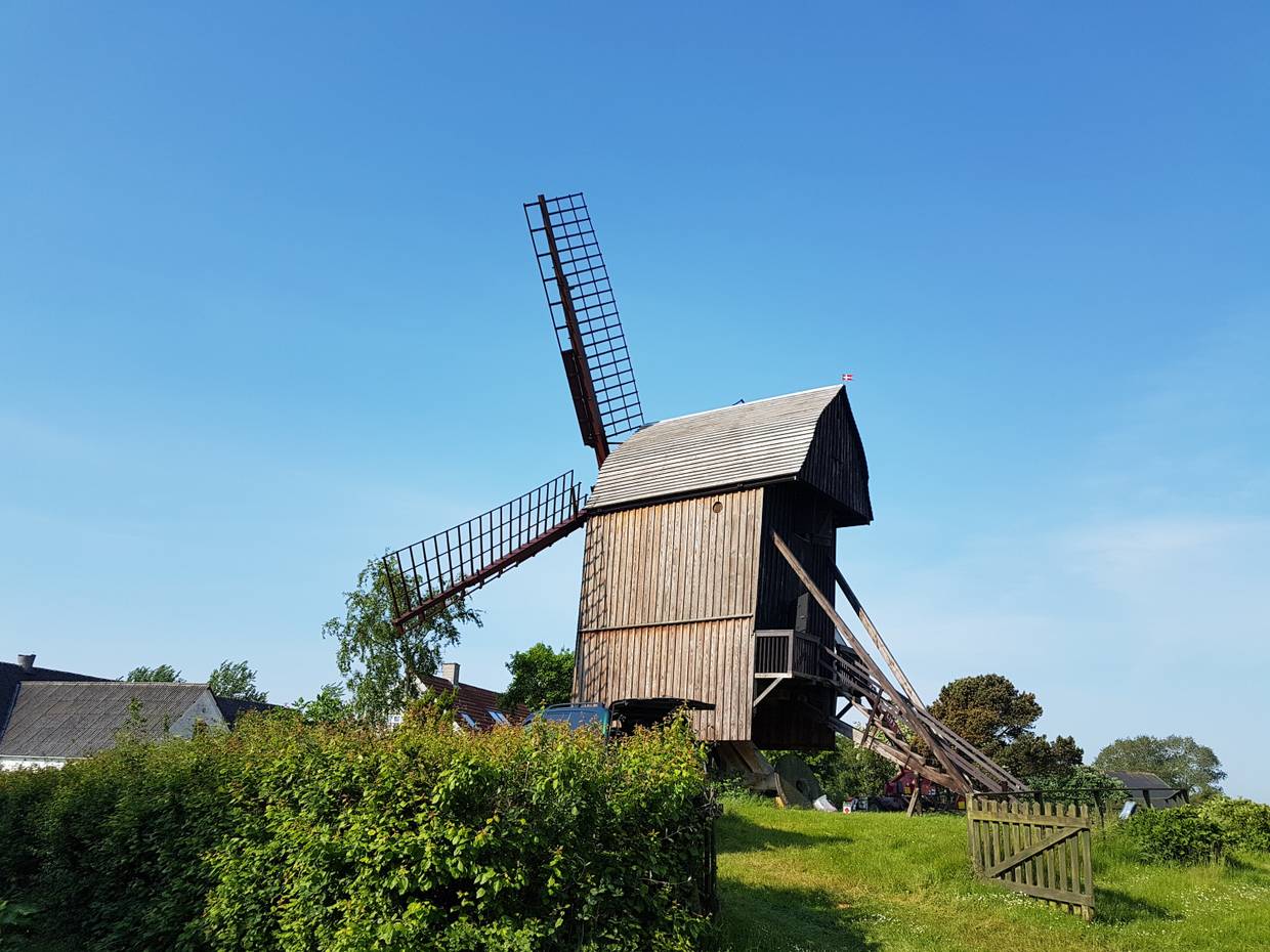 Alte Mühle aus Holz auf einer grünen Wiese