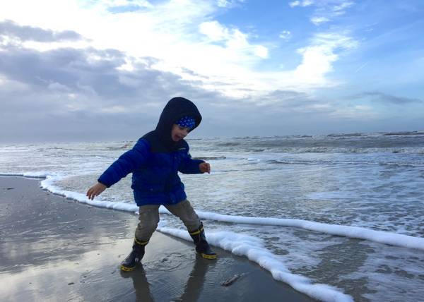 Kind am Meer mit Winterjacke