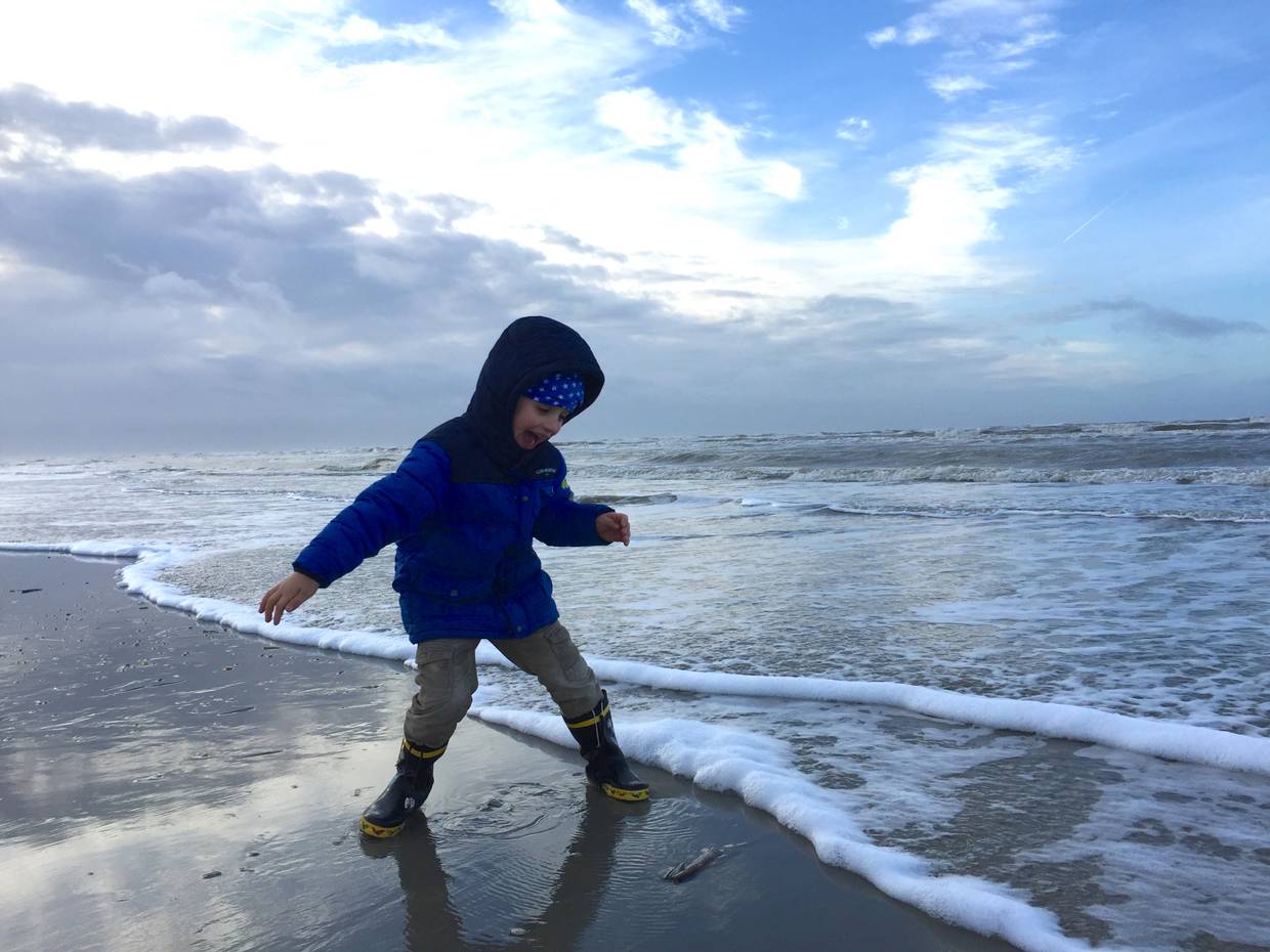 Kind am Meer mit Winterjacke