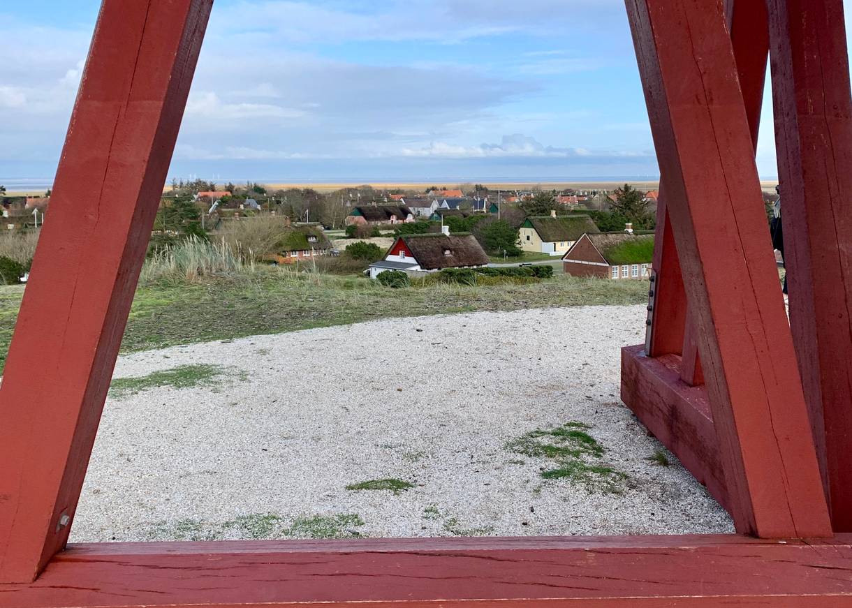 Blick auf das Dorf zwischen den Holzpfählen eines Turms hindurch