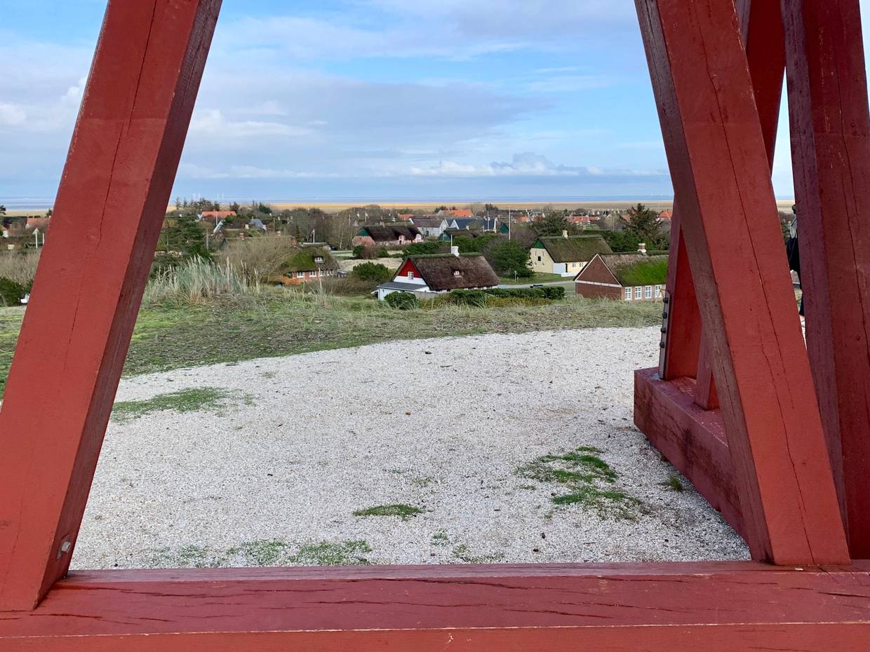 Blick auf das Dorf zwischen den Holzpfählen eines Turms hindurch