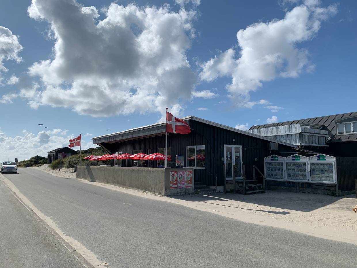 Schwarzes Holzgeäude mit einem Restaurant und Außenterrasse