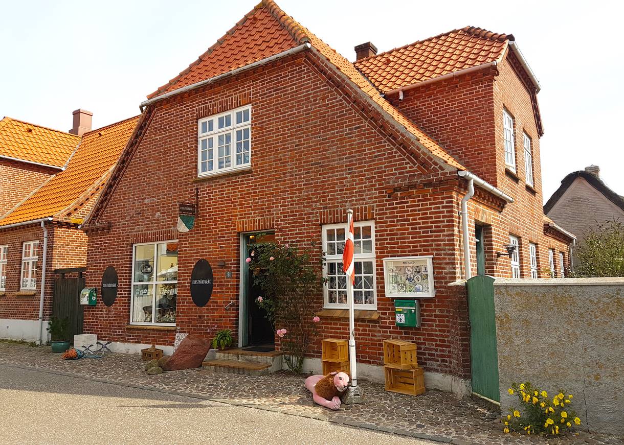 Wohnhaus mit einem Laden, Dannebbrog und etwas Deko vor der Tür