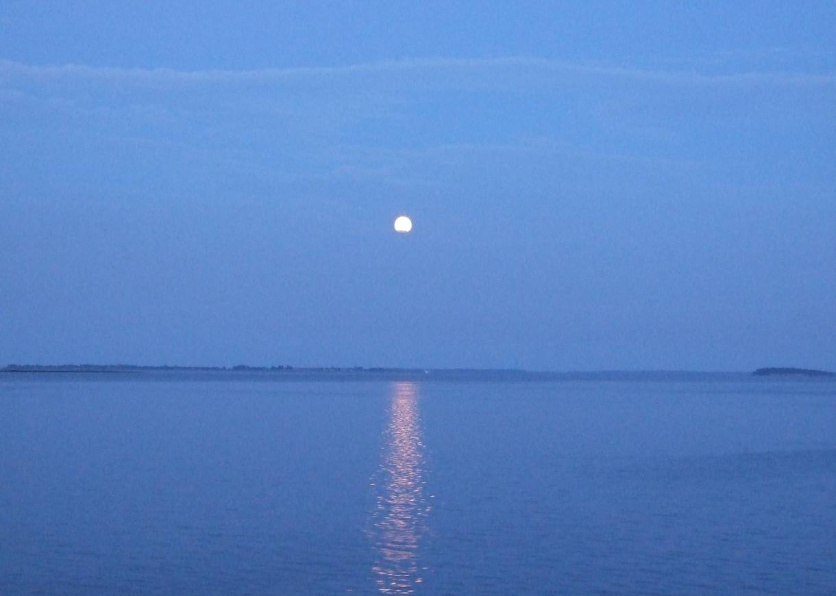 Blaues Licht bei Vollmond über dem windstillen Meer
