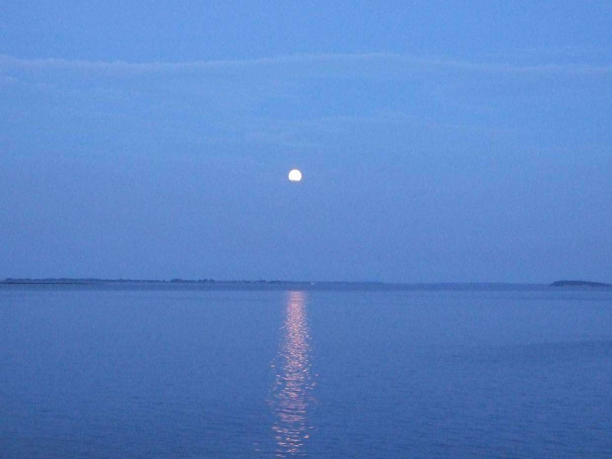 Blaues Licht bei Vollmond über dem windstillen Meer