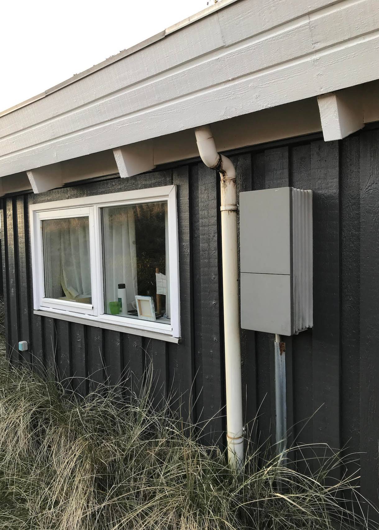 Grauer Kasten an einer Ferienhauswand