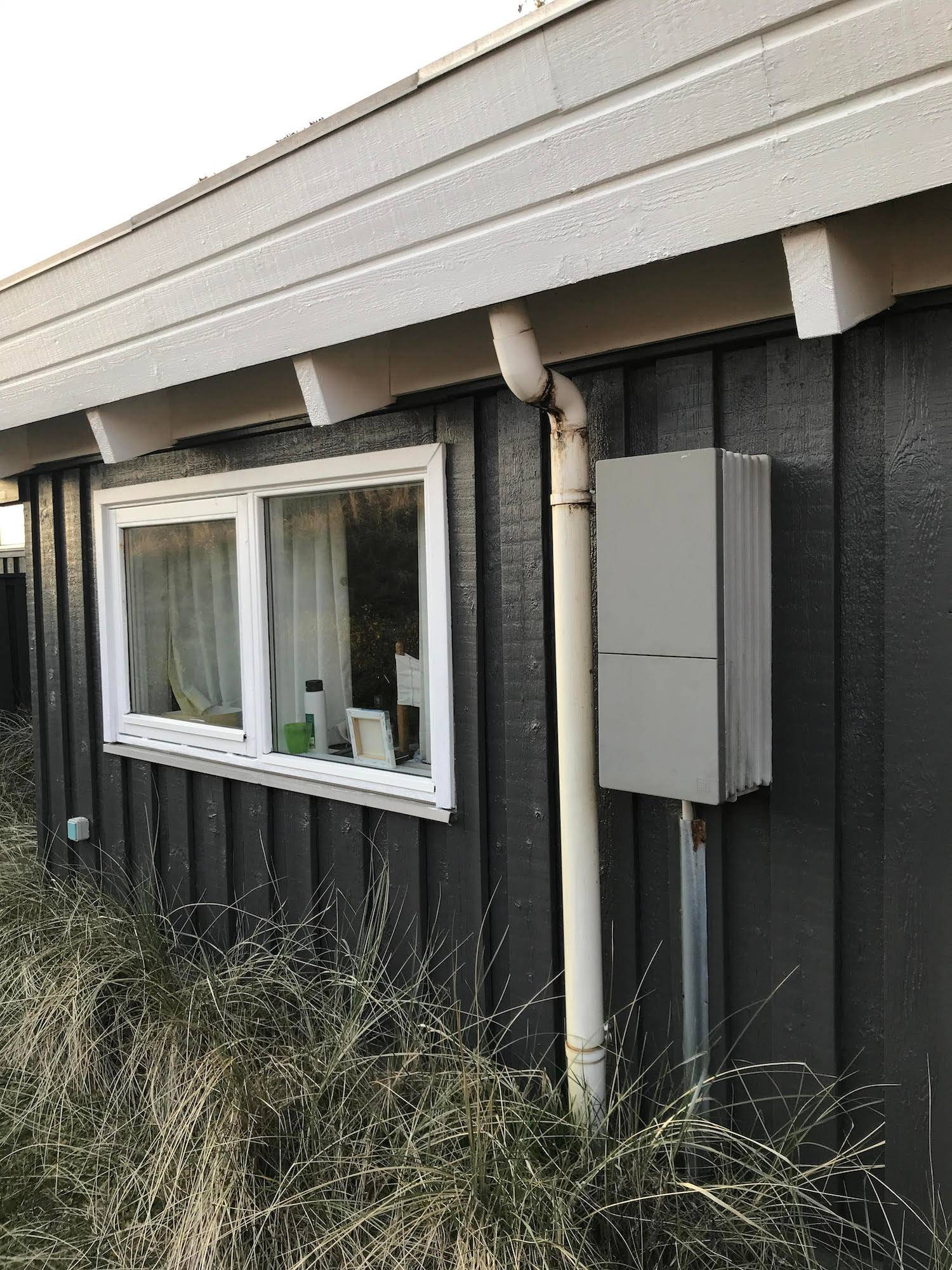 Grauer Kasten an einer Ferienhauswand