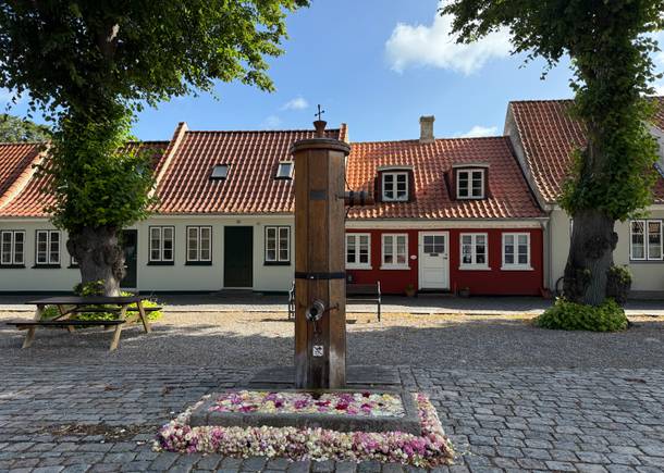 Historischer Marktplatz mit kleinen Häusern und einer alten Pumpe