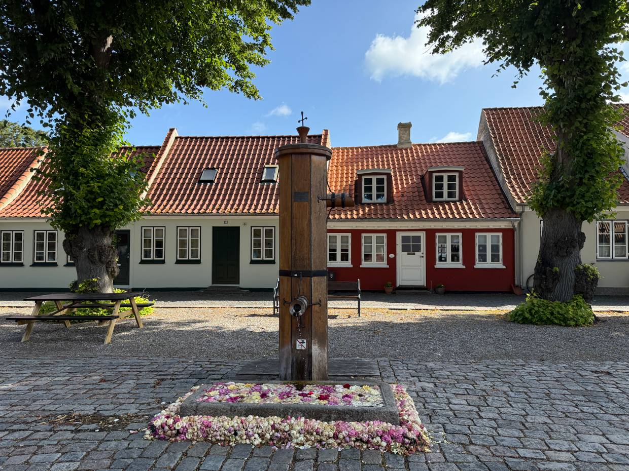 Historischer Marktplatz mit kleinen Häusern und einer alten Pumpe