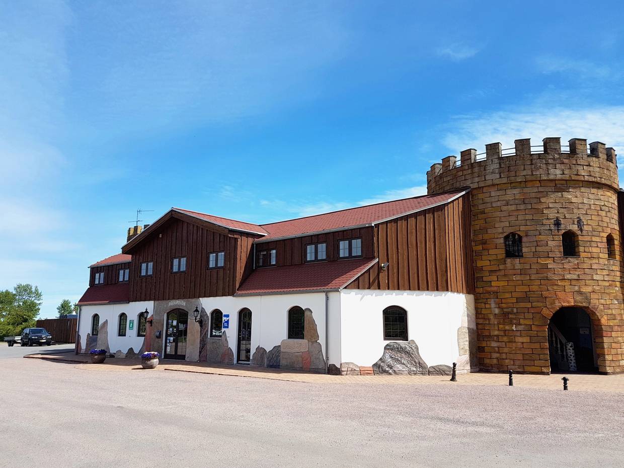 Empfangsgebäude am Campingplatz mit einem runden Burgturm an der Seite