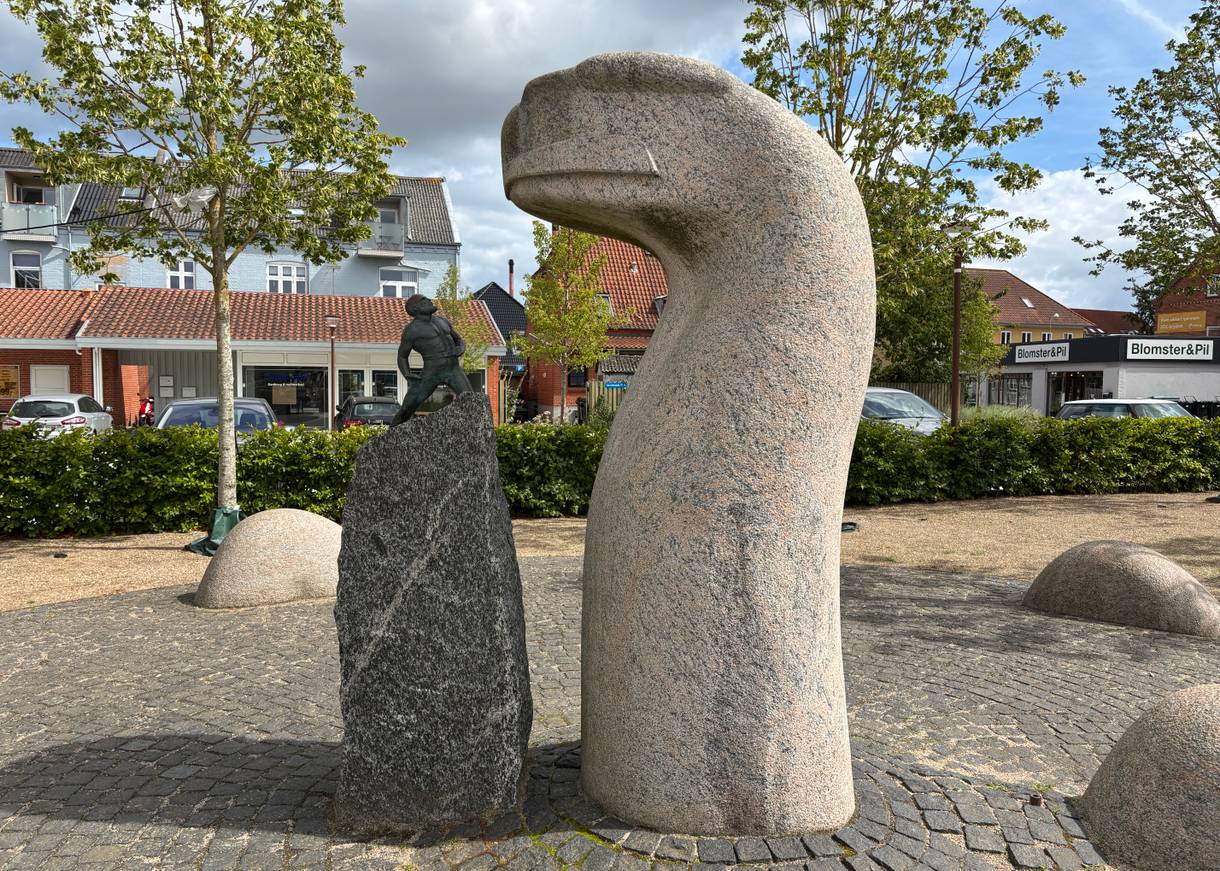 Skulptur der Midgardschlange gegenüber einer kleinen Skulptur von Thor 