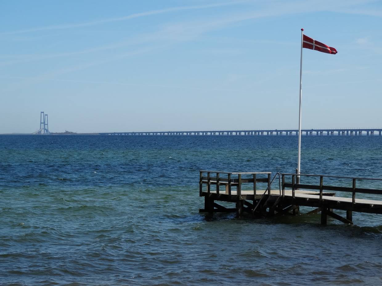Steg mit dänischer Fahne, dahinter ein lange Brücke