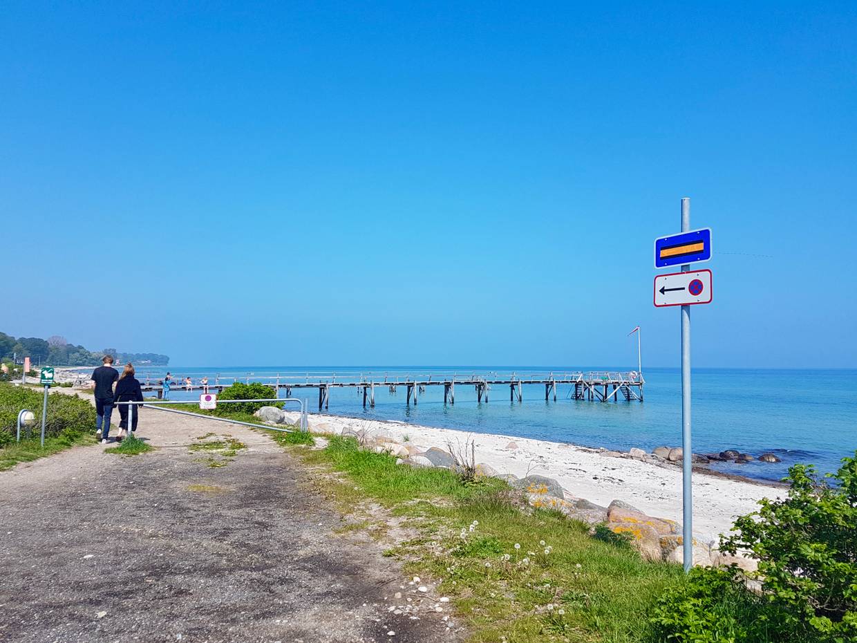 Strandpromenade mit einen Pärchen, am Strand ein Badesteg