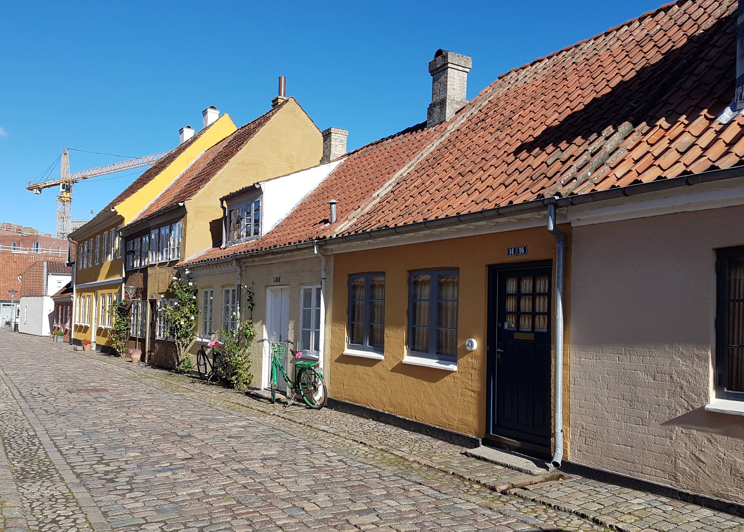 Kleine, gelbe Wohnhäuser an einer Kopfsteinpfastegasse 