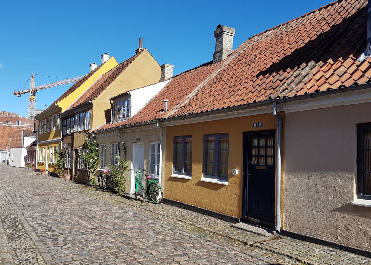 Kleine, gelbe Wohnhäuser an einer Kopfsteinpfastegasse 