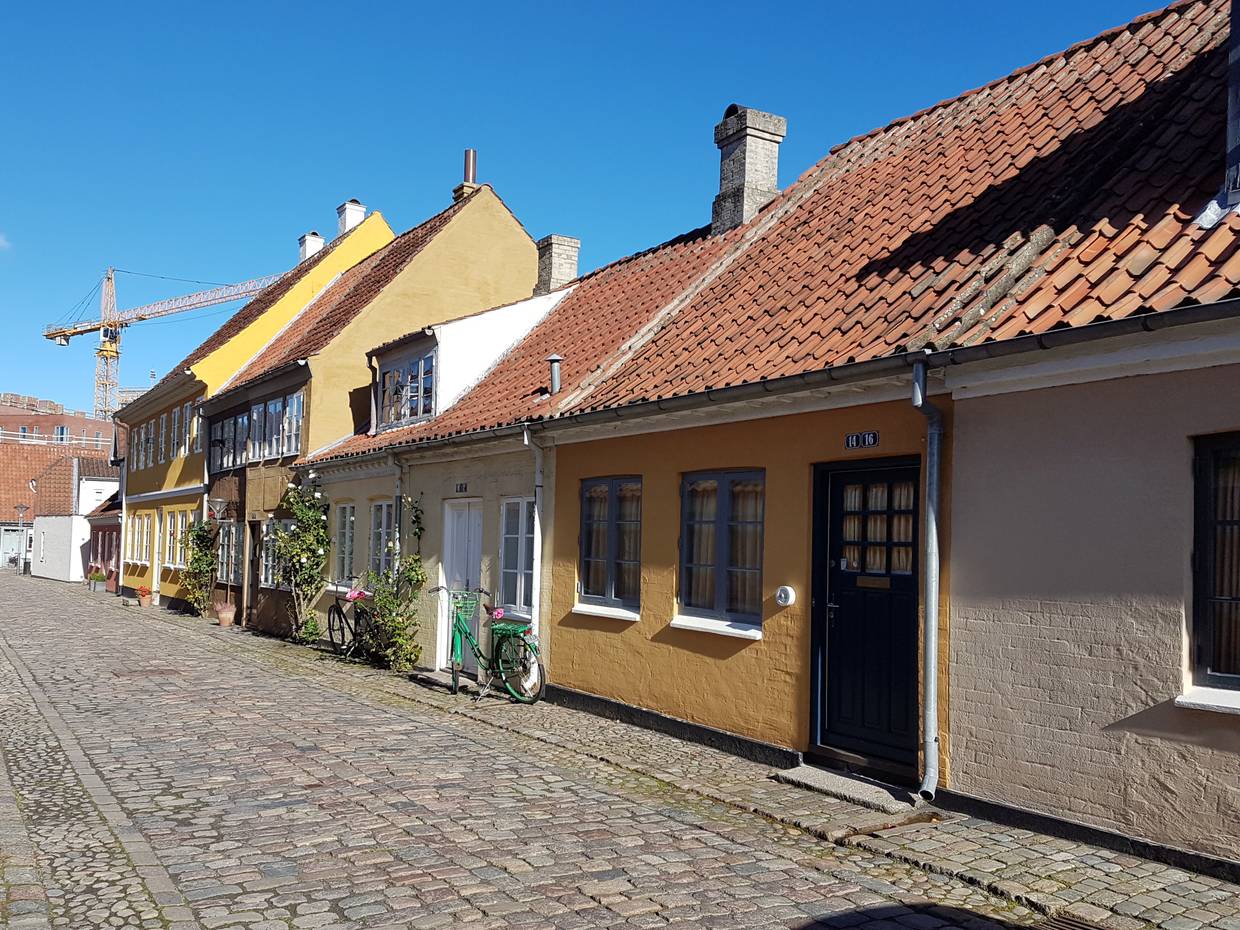 Kleine, gelbe Wohnhäuser an einer Kopfsteinpfastegasse 