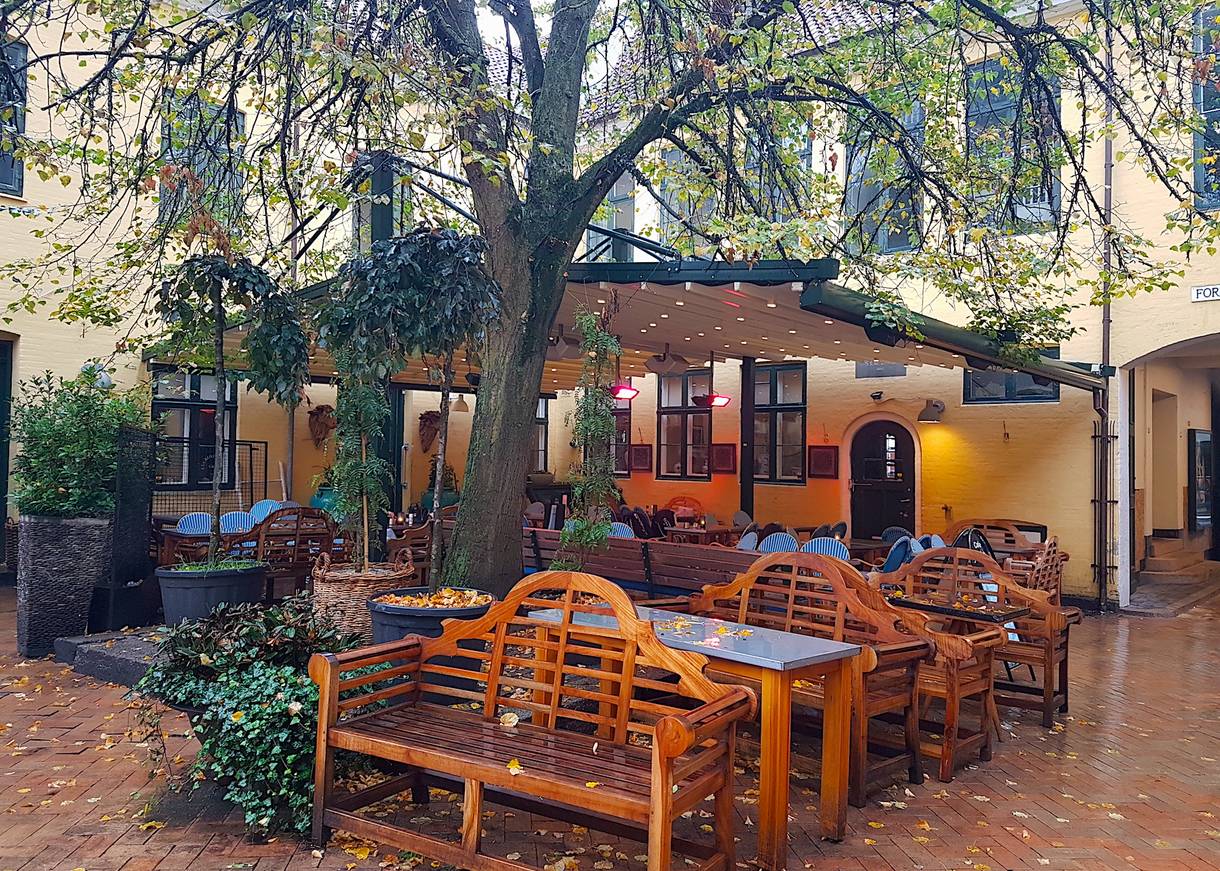 Biergarten unter Sonnenschirmen im Regen