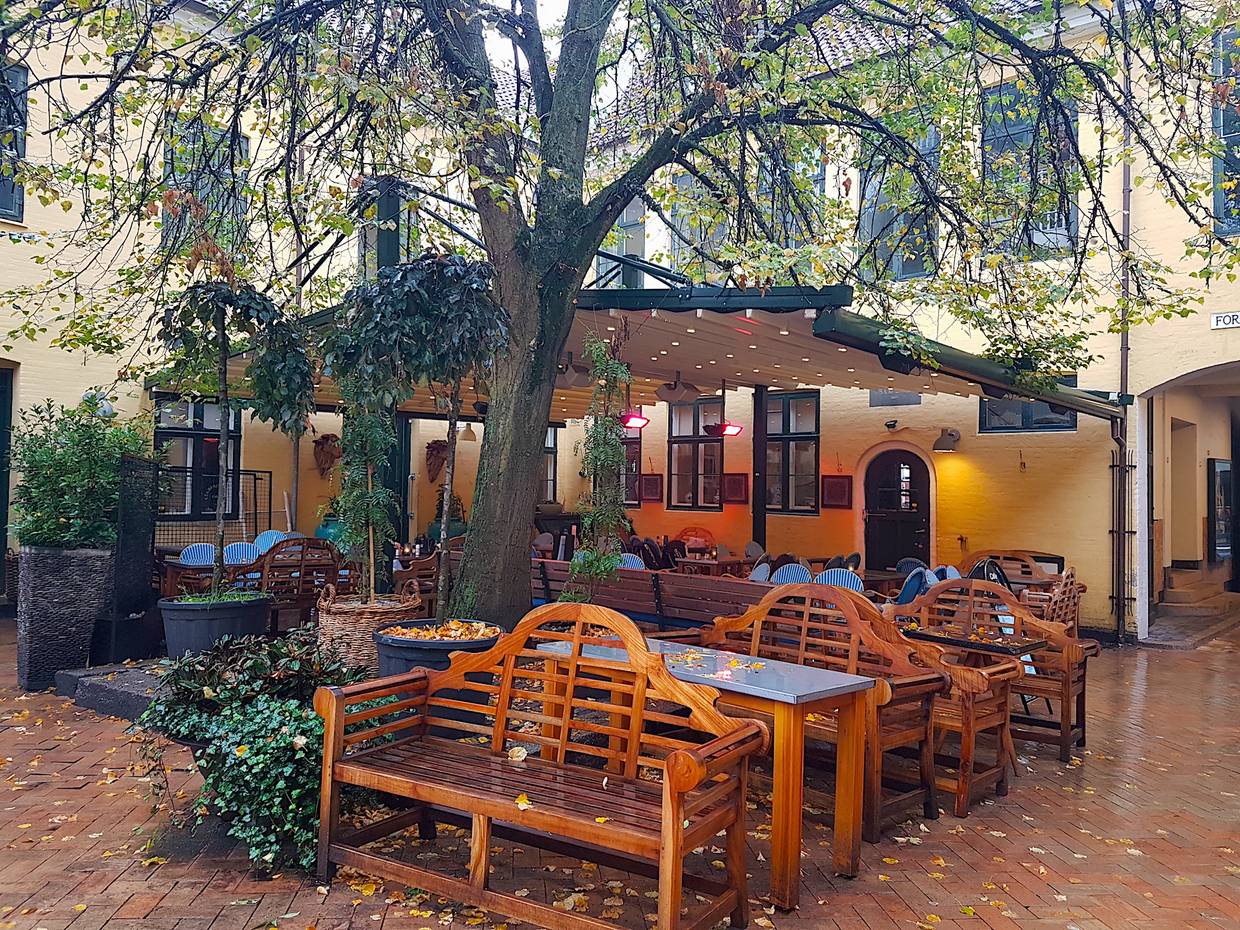 Biergarten unter Sonnenschirmen im Regen