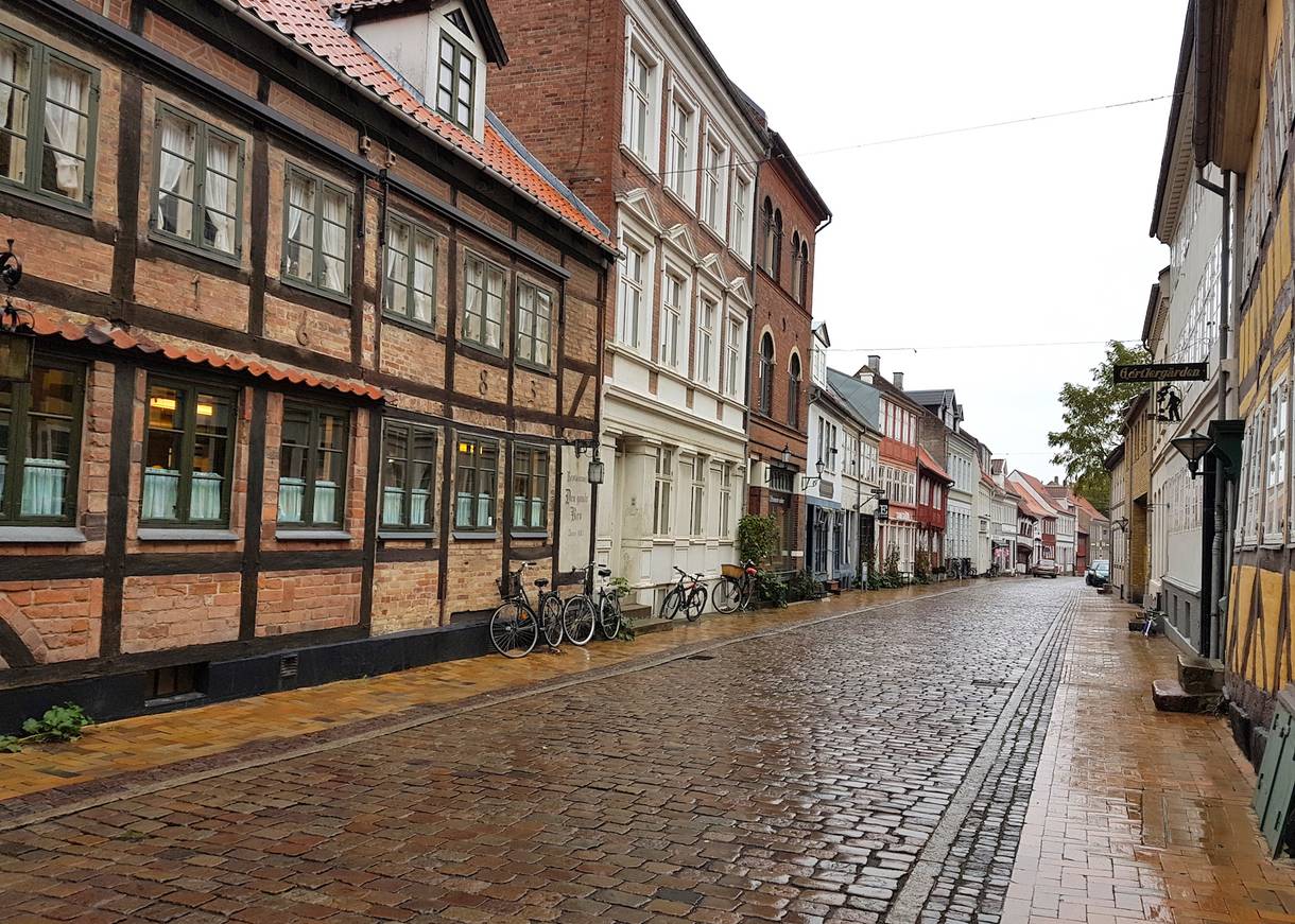 Kopfsteinpflasterstraße mit alten, mehrsöckigen Häusern