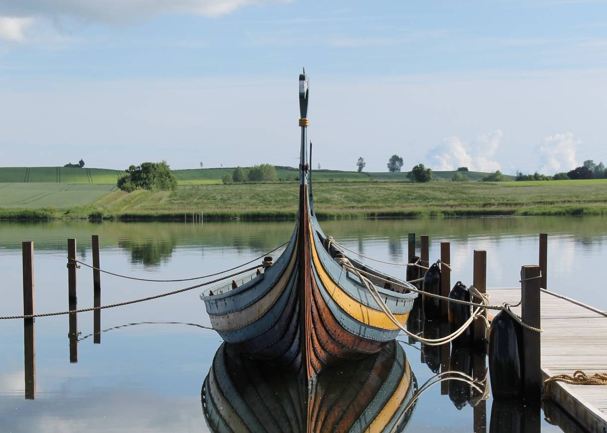 Wikingerboot vertaut an einem Holzsteg am Wasser