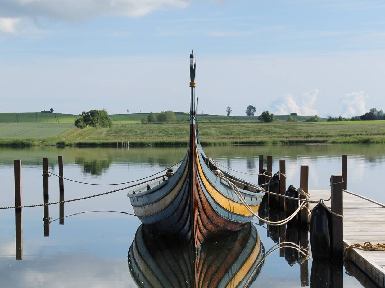 Wikingerboot vertaut an einem Holzsteg am Wasser