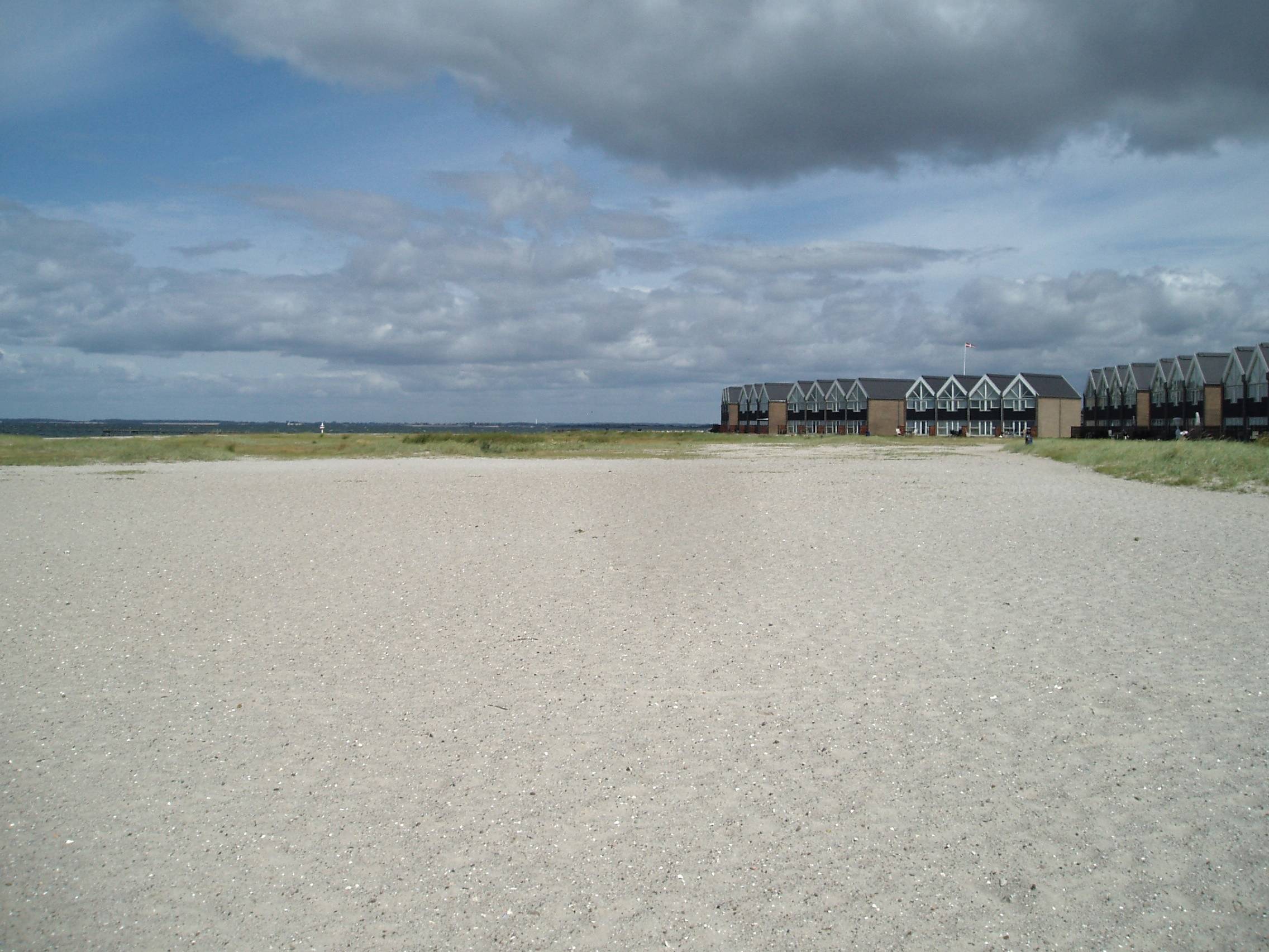 Breiter Strand, im Hintergrund Reihenhäuser