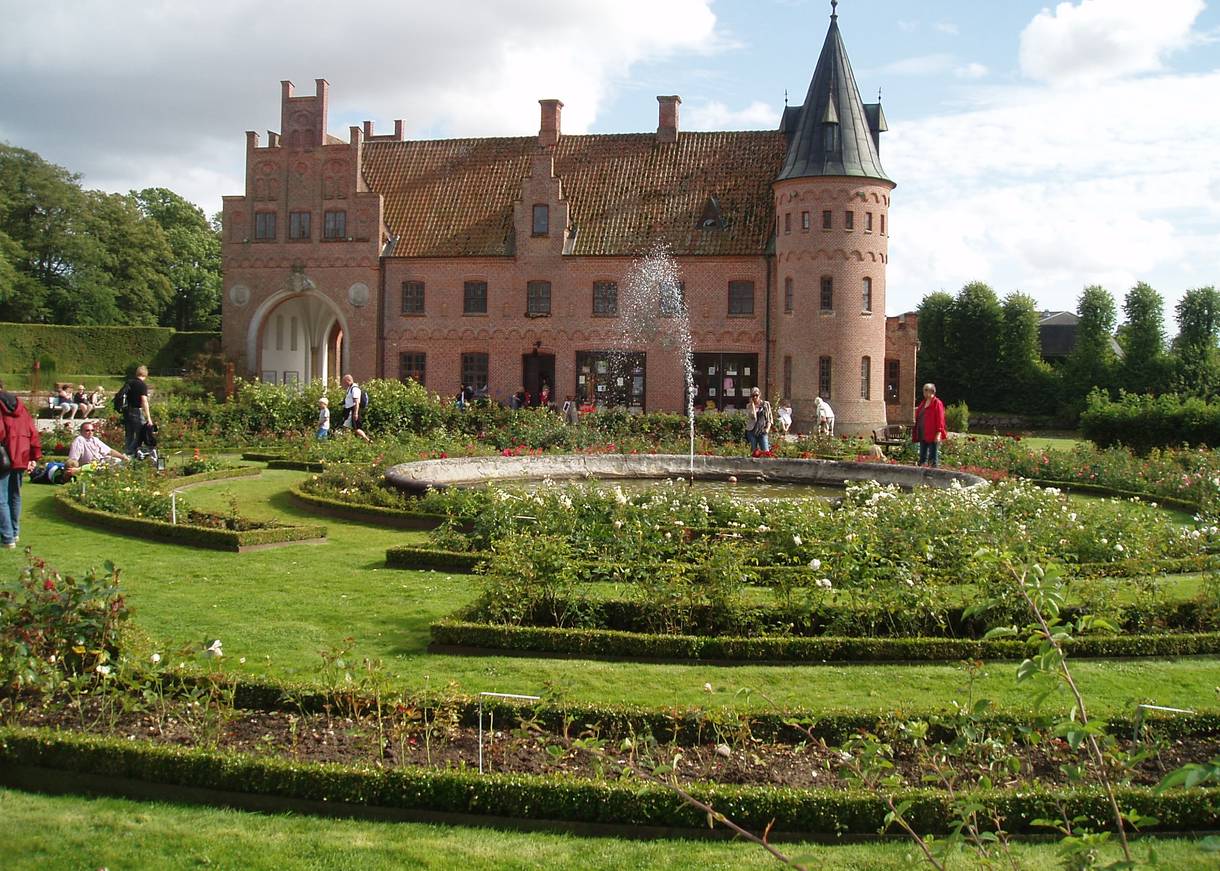 Backsteinschloss hinter einem Rosenlabyrinth