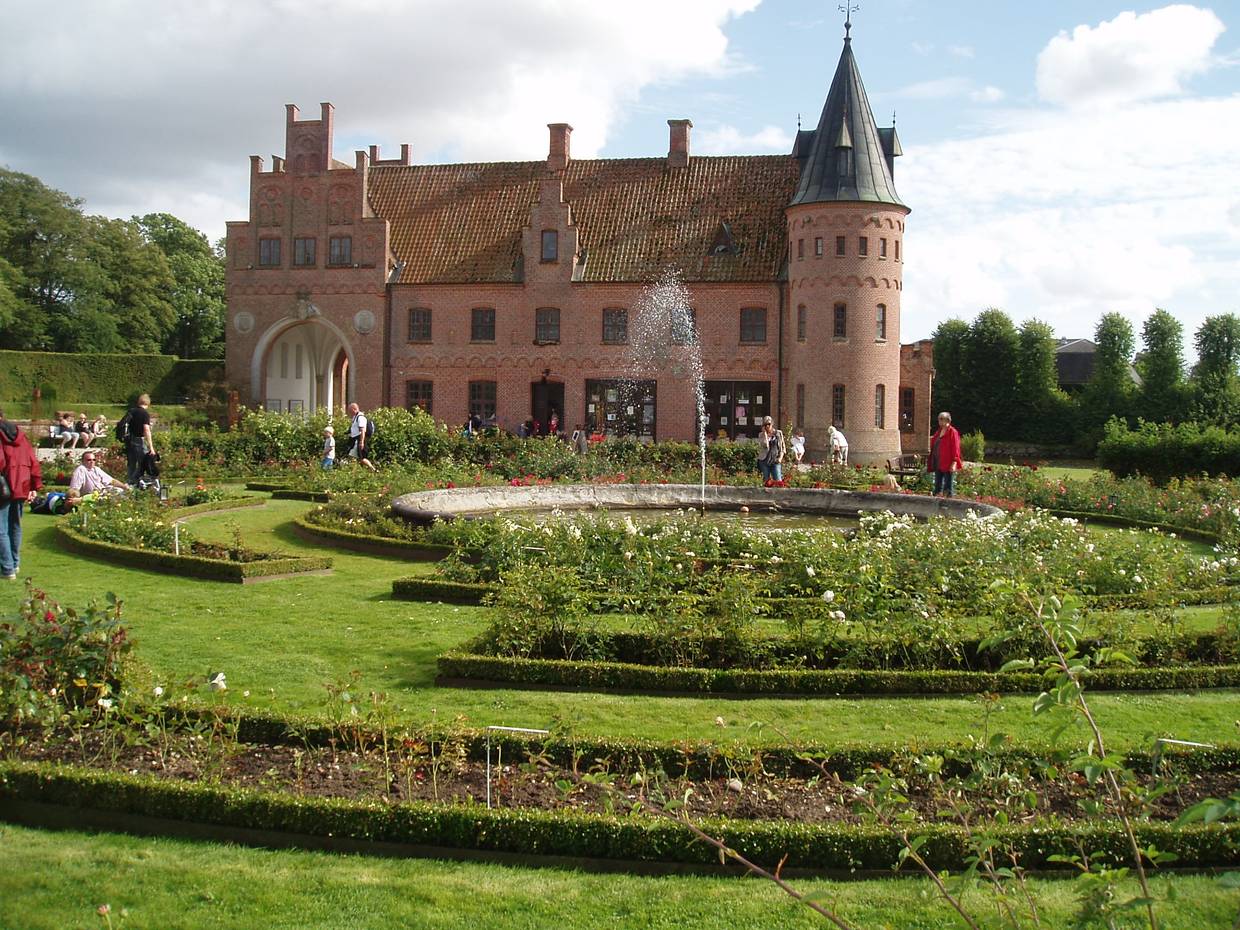 Backsteinschloss hinter einem Rosenlabyrinth