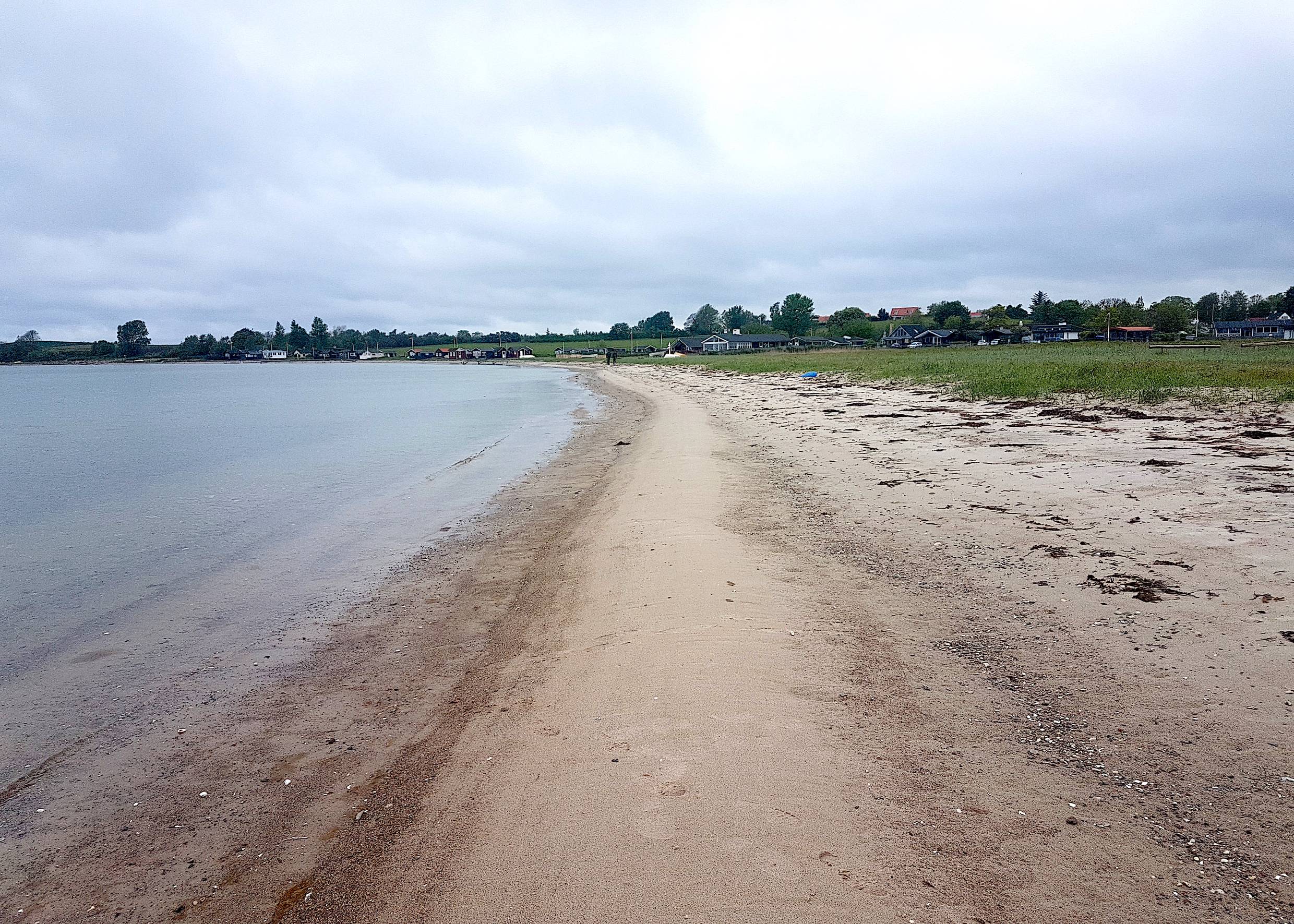 Sandstrand, im Hintergrund Ferienhäuser