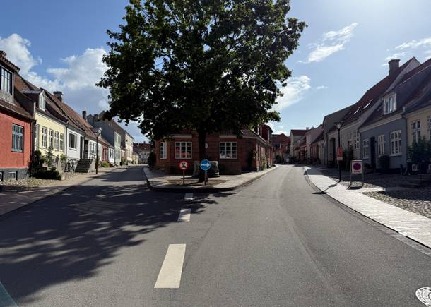 Blick durch zwei kleine Gassen durchtrennt von einem kleinen Platz mit Baum und Brunnen